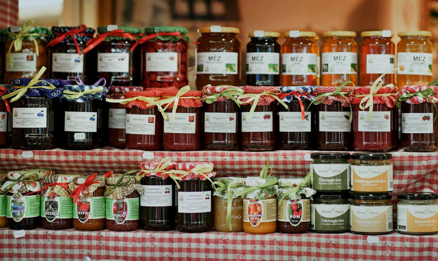 Étagères garnies de pots de confiture coiffés de tissu à carreaux